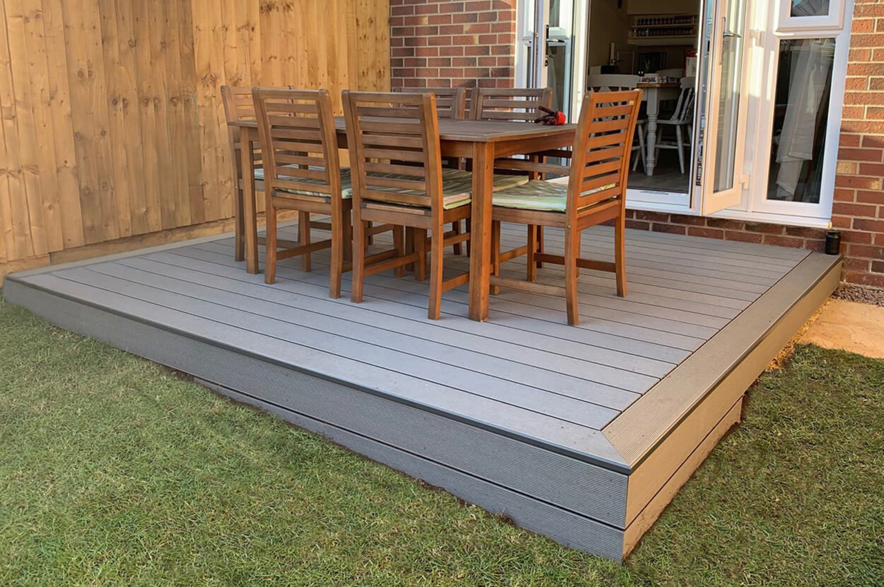 Stone grey composite decking area with dining table and bullnose edge