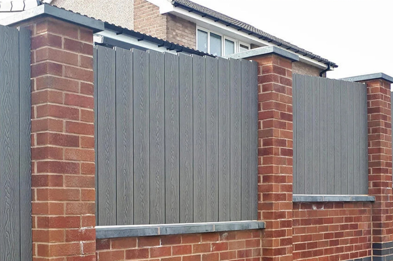Cladco Woodgrain Composite Decking Boards have been installed as vertical fencing panels around this home
