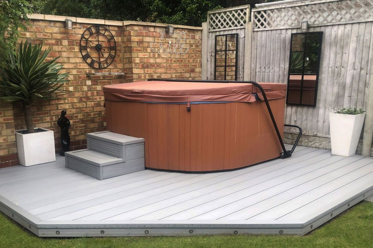 Woodgrain Effect Composite Decking in Light Grey installed around a hot tub