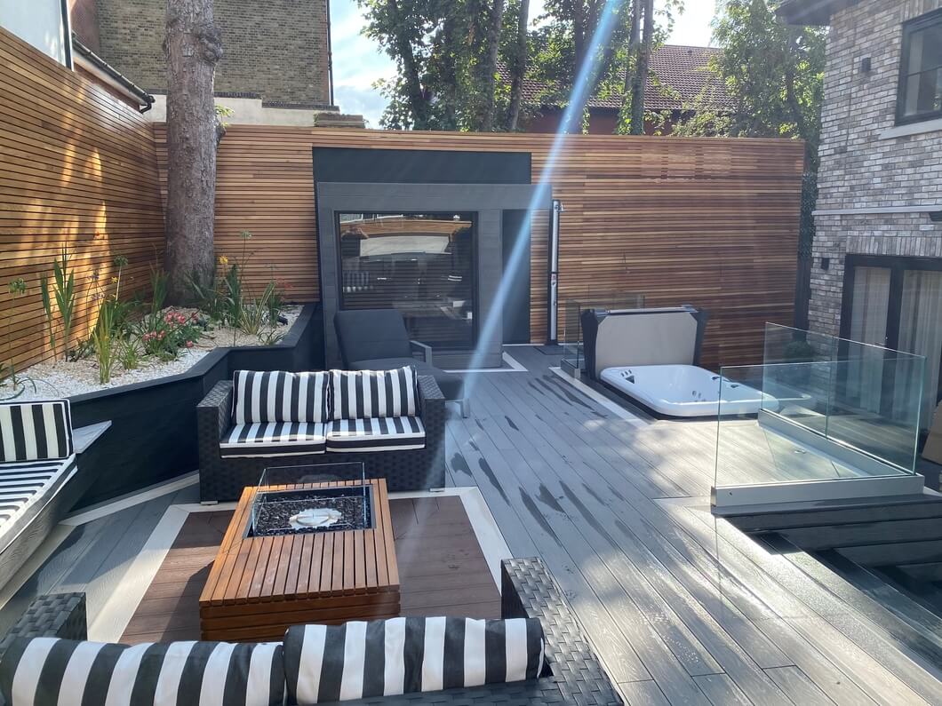 Glass balustrade separating the home from the raised Cladco composite decking area, enhancing safety and modern aesthetics