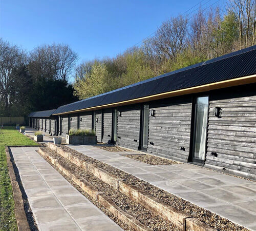 Restored Farm Buildings with Black Corrugated Roofing – The Hopper Huts
