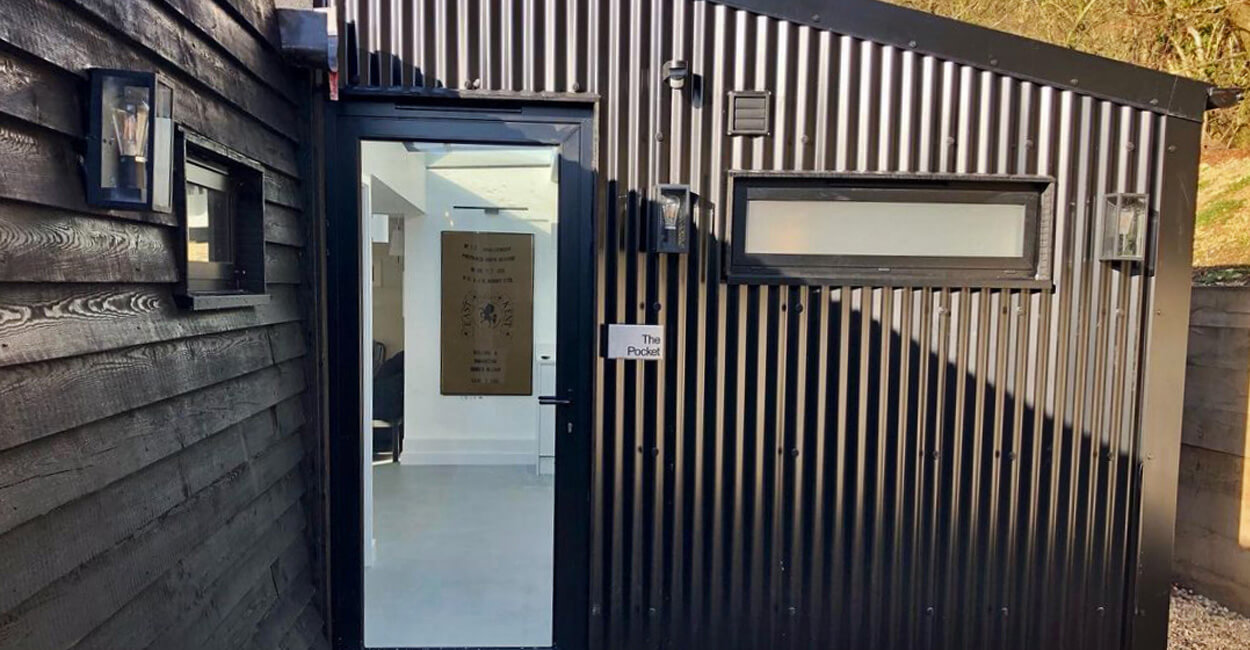 Side view of ancillary buildings at The Hopper Huts site clad with Cladco black corrugated steel sheets, enhancing the industrial heritage aesthetic