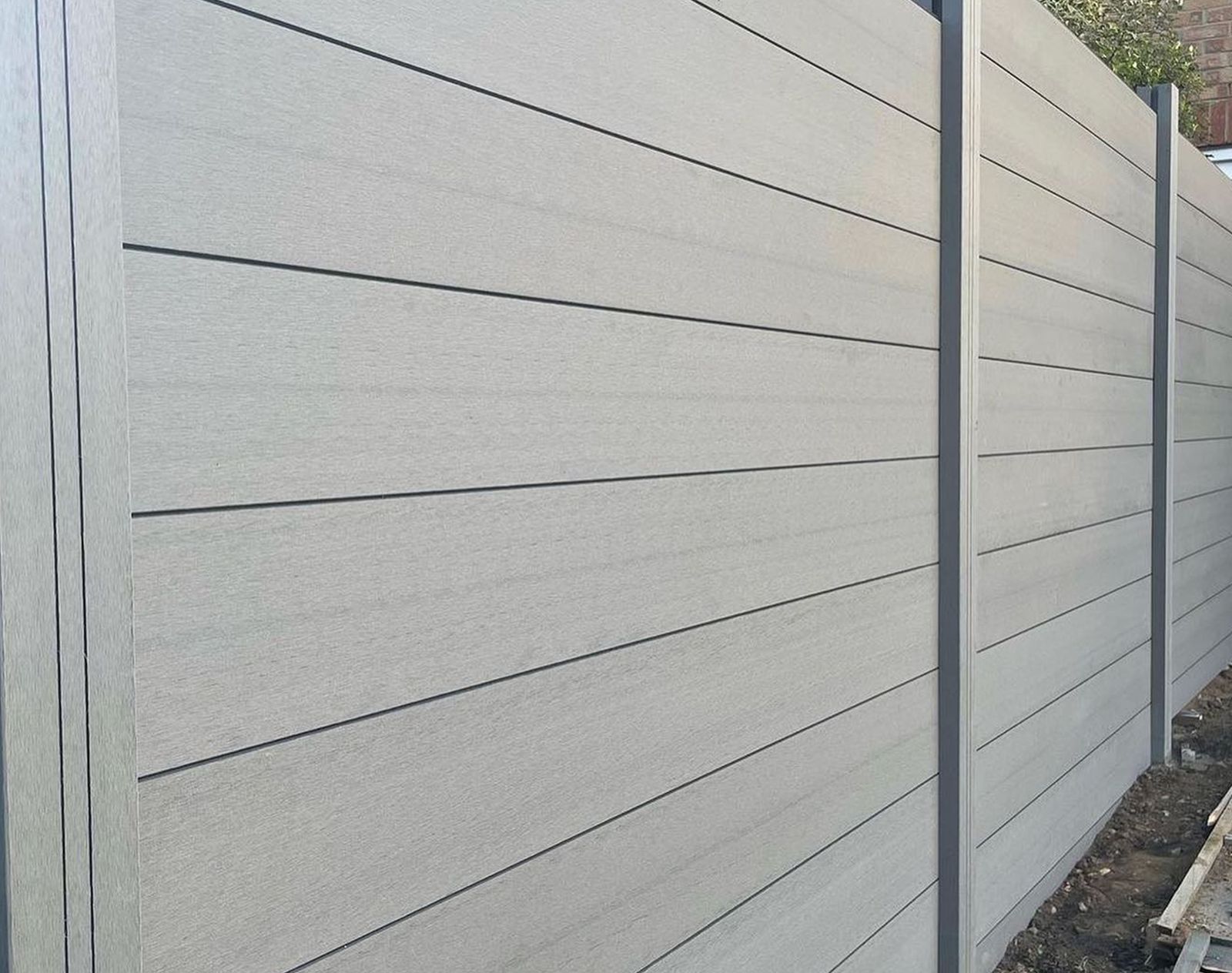 Light grey composite fencing panels with smooth horizontal boards, offering a clean, modern, and low-maintenance boundary solution.
