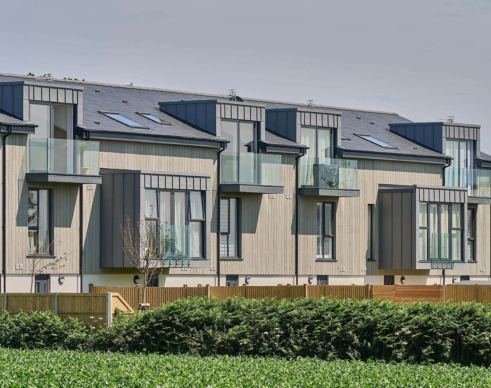 Modern apartment buildings featuring vertical Millboard cladding with a light oak finish, combining sustainable style and contemporary architecture.
