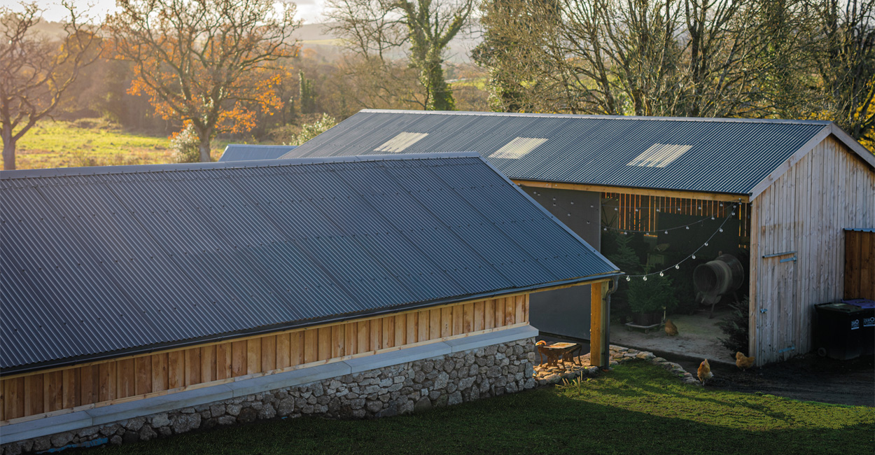 Farmyard at The Dartmoor Shepherd showcasing newly installed Cladco corrugated steel roofing on workshop and woolshed