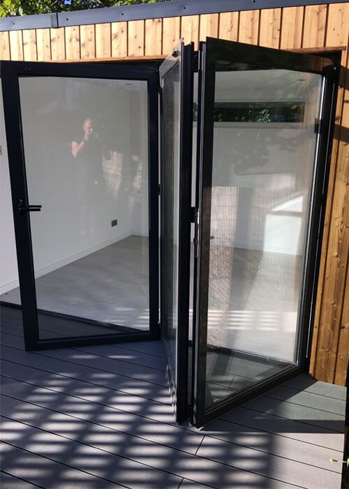 Garden room illuminated at dusk, showcasing the durability and aesthetic appeal of Cladco composite decking.