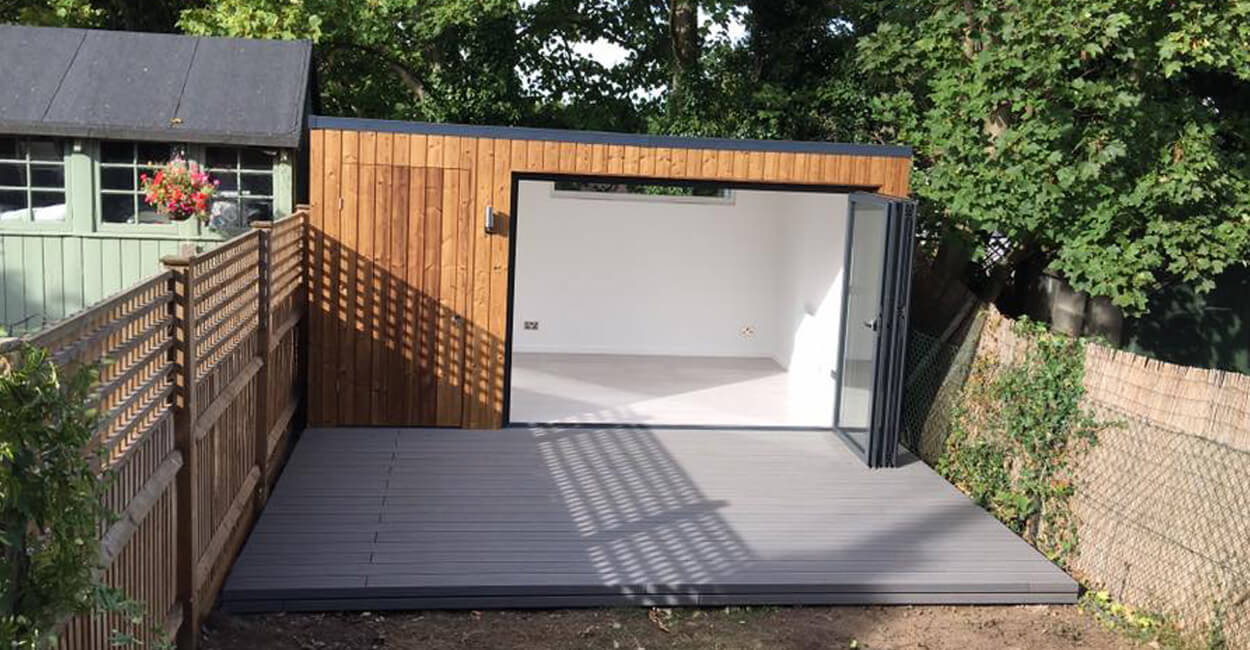 Bi-fold doors seamlessly connecting the interior garden room to the Cladco composite decked patio area.