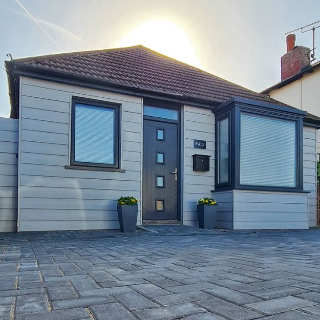 Fibre Cement Wall Cladding Boards in Light Grey have a traditional Woodgrain appearance and contrast perfectly with the darker finish of the door and windows. This light and airy garden room as been finished with Fibre Cement Wall Cladding in light grey
