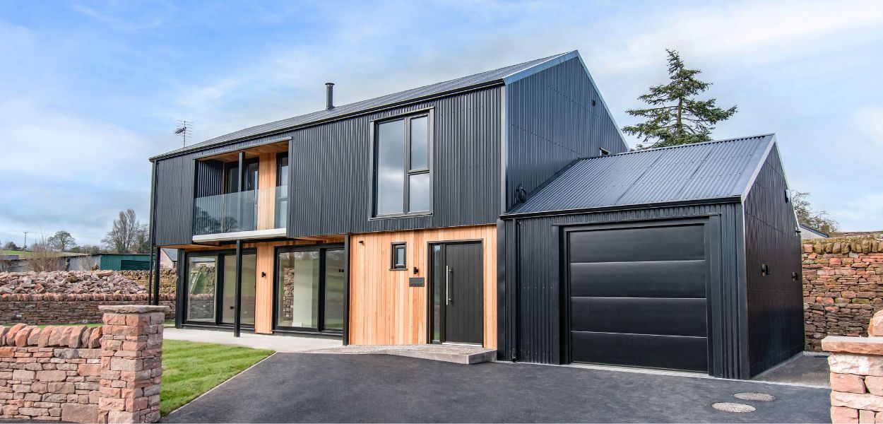 Front elevation of modern barn-style home showcasing Cladco black corrugated steel cladding and matching custom flashings