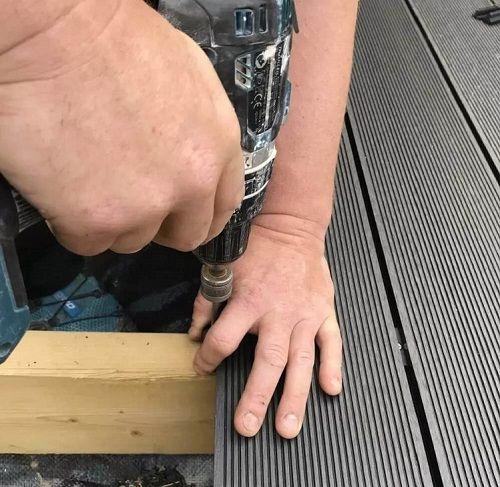 Close-up of T-Clip system securing charcoal composite decking boards on timber joists