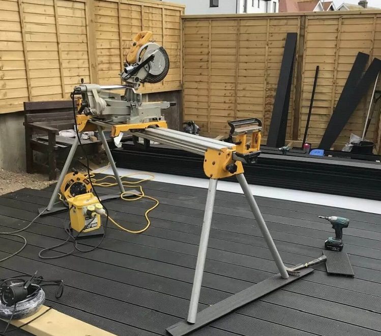 Precision cutting of composite decking boards to fit unique garden layout during installation