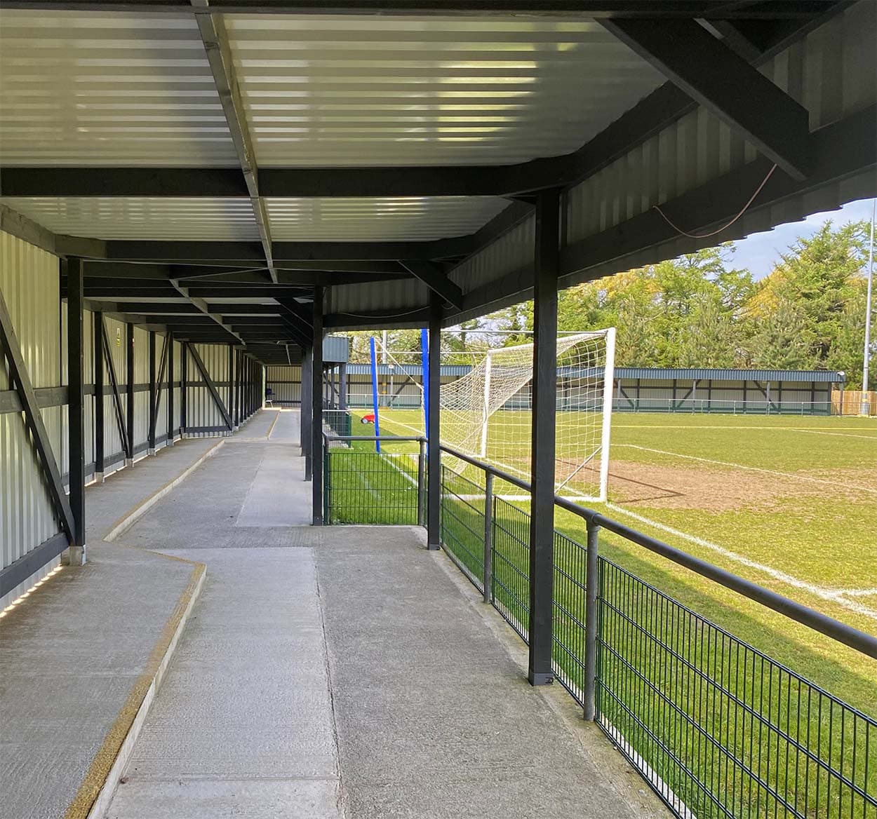 Interior perspective of the covered spectator area at Bolitho Park, highlighting the protective roofing and cladding installation.
