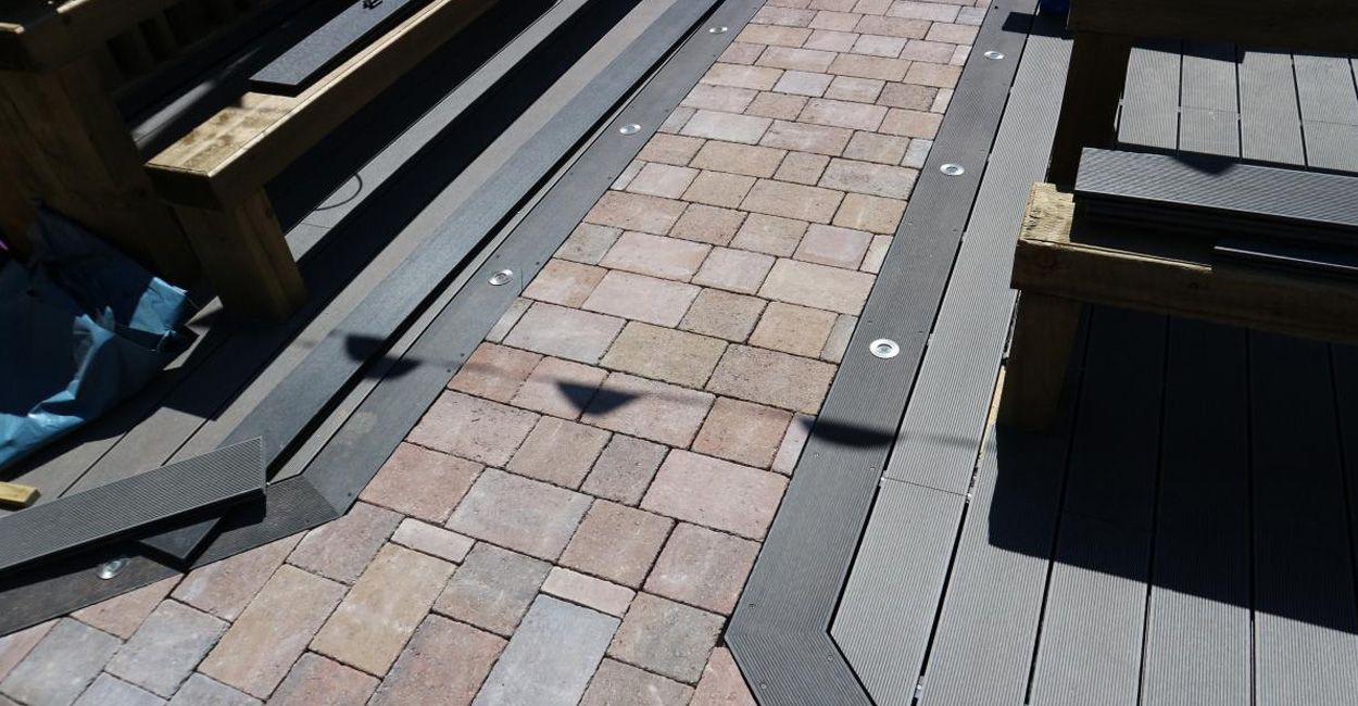 Installation process of Cladco composite decking at Fountain Inn, demonstrating the transformation of the pub's garden area.