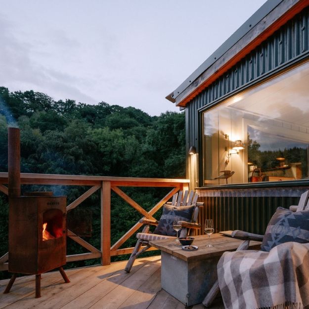 Cove Valley cabin exterior combining Cladco corrugated steel cladding with natural timber elements in a rewilded Devon setting