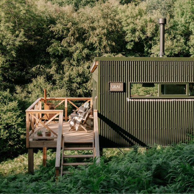 Ukai cabin at Cove Valley featuring Olive Green Cladco corrugated steel roofing and cladding, blending into the Devon woodland
