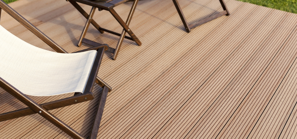 Deck chairs and table on timber decking with grooves.