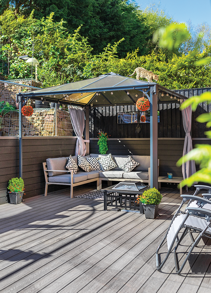 Garden seating area covered by a shelter with Light Grey Composite Plastic Decking being used on the patio.