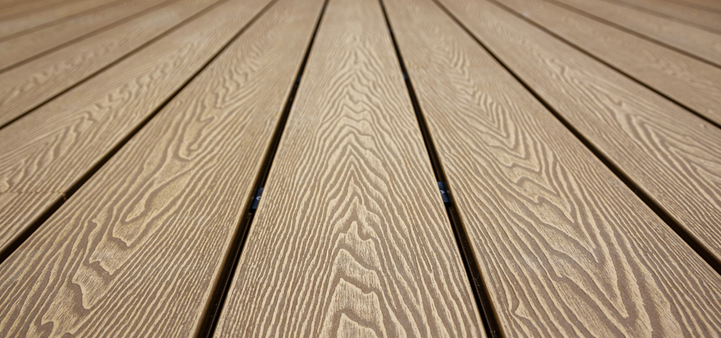 Close up of Composite Decking in a natural Teak colour.