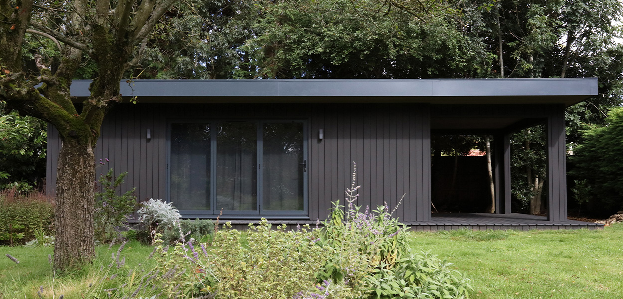 Modern garden art studio featuring Cladco Charcoal Composite Cladding in Original finish and Woodgrain Composite Decking, designed by Isle Architects