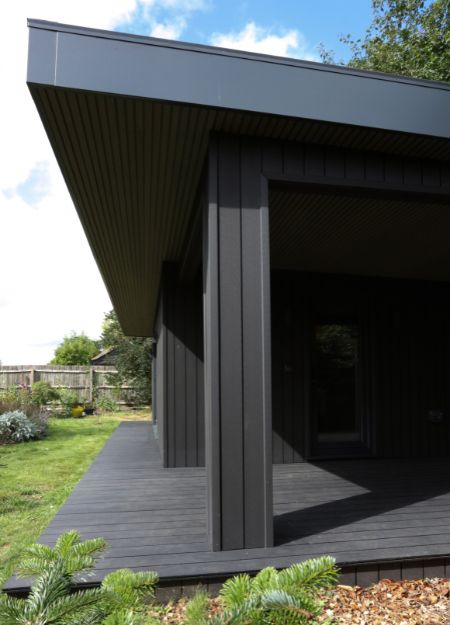 Detail of Cladco Charcoal Composite Cladding installed vertically and Woodgrain Composite Decking on contemporary garden studio by Isle Architects
