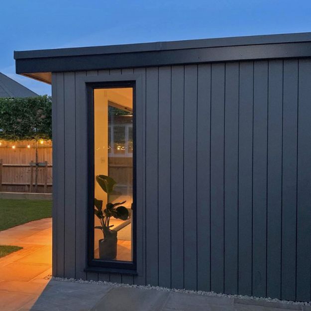 Contemporary garden office featuring Cladco Stone Grey Composite Cladding and full-length window by Wo-man Cave Ltd