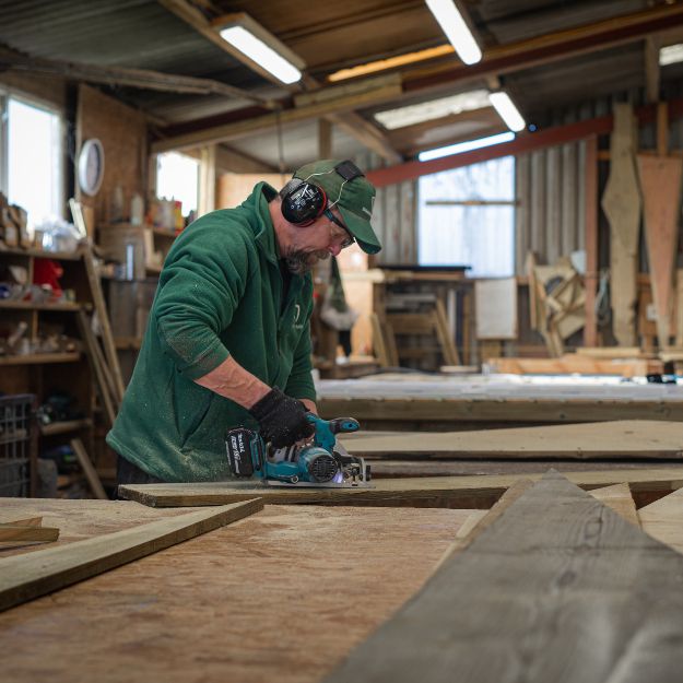 Shields Buildings craftsmen cutting timber for bespoke garden building construction