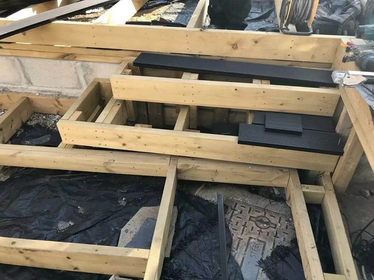 Multi-level timber frame structure built to support composite decking and steps in modern garden